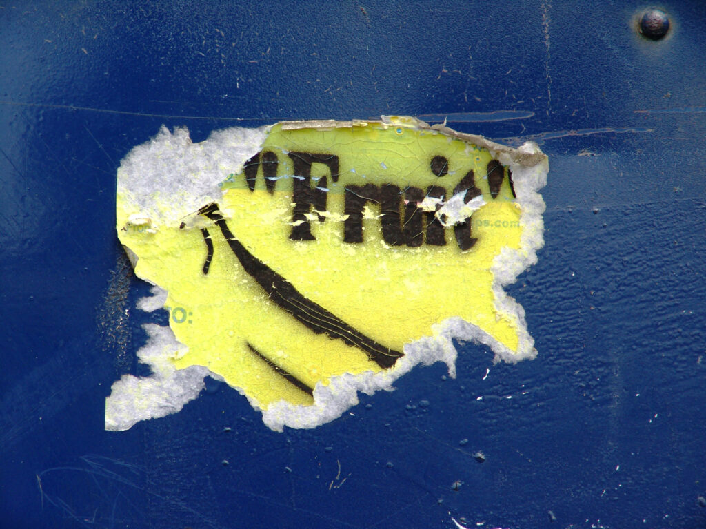 Postal Service sticker painted yellow, stenciled with a picture of a banana and the word fruit in quotations.